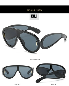 Detailed views of futuristic oversized shield sunglasses with gold metal accents