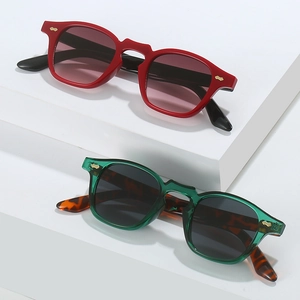 Punk hip hop sunglasses with geometric frames and gold winged accents on white steps