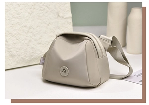 Close-up of beige shell-shaped nylon crossbody bag with metallic brand logo detail