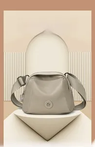 Detail of a beige oxford shell bag with wide nylon strap and geometric 3D background
