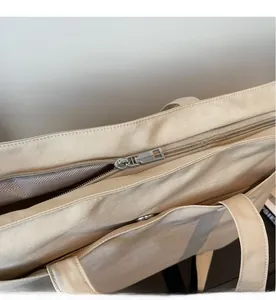 Detail of smooth metal zipper and durable Oxford fabric texture on the beige tote bag