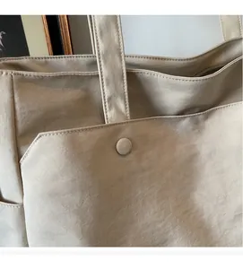 Detailed close-up of soft beige oxford fabric with high-quality stitching on a tote bag