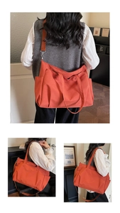 Detail of orange thickened oxford tote showing side pocket and durable strap texture