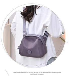 Detailed back view of purple nylon crossbody shell bag on model showing adjustable strap