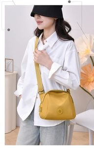 Close-up of bright yellow oxford fabric shell bag worn by model in casual setting