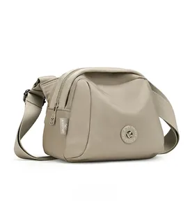 Side view of khaki oxford fabric crossbody shell bag with adjustable shoulder strap