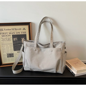 Detail of multi-pocket oxford tote bag showing side storage and durable top handles