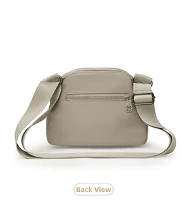 Detail view of the back zipper pocket and adjustable strap of the beige Oxford shell bag