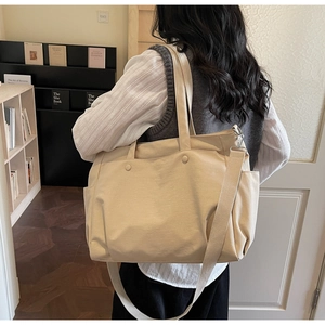 Detailed view of beige oxford tote bag with sturdy handles and adjustable shoulder strap