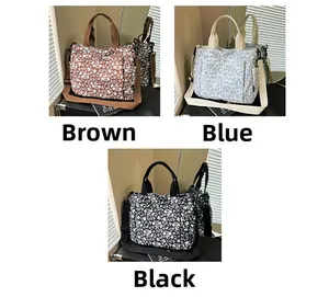 Detailed view of large floral canvas tote bags in brown, blue, and black color options