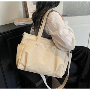 Detailed side pocket and thick Oxford fabric texture of large beige tote bag with strap