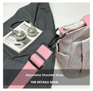 Detail of adjustable pink shoulder strap with metal hooks on floral tote bag