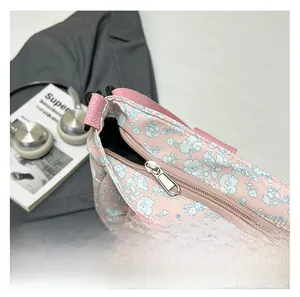Detail of smooth silver zipper on a pink floral tote bag with fabric strap handles