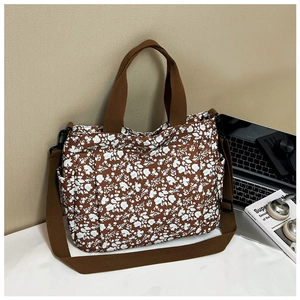 Floral canvas tote bag next to a laptop and books in a lifestyle daily setting