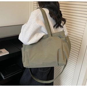 Detail of olive green canvas tote bag with adjustable shoulder strap and side pockets