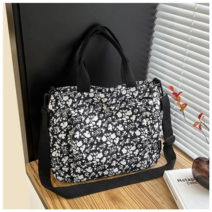 Detail of floral tote bag showing durable straps and detachable shoulder strap