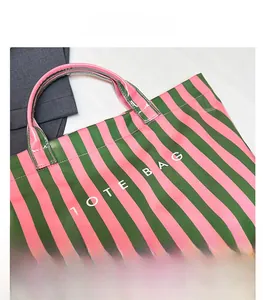 Vue détaillée d'un sac cabas à rayures roses et vertes avec une impression de texte blanc