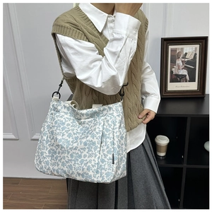 Close-up of floral canvas tote bag featuring side pocket and durable metal hardware