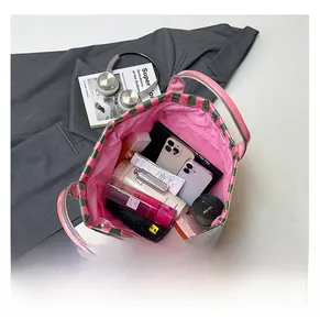 Intérieur spacieux du sac cabas rayé avec doublure rose pour les essentiels du voyage