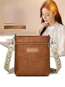 Detail of embossed paisley floral crossbody bag with ethnic patterned woven strap