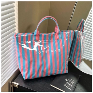 Détail du sac cabas à rayures roses et bleues avec finition brillante et poignée de port