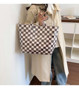 Detail of checkered tote bag showing the glossy texture and 'TOTE BAG' printed text