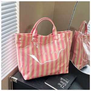 Gros plan du sac fourre-tout à rayures roses et beige avec surface brillante imperméable