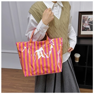 Gros plan sur le sac fourre-tout à rayures orange et rose avec finition brillante et texte