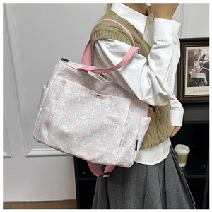 Detail of pink floral canvas tote bag with snap-button front pocket and side compartments