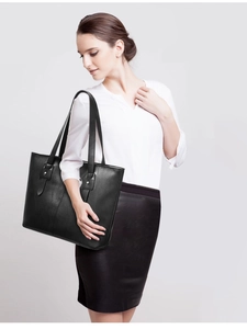 Close-up of black leather tote bag with silver studs and reinforced shoulder straps