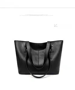 Front view of a black tote bag featuring pebbled texture and silver rivet details