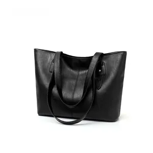 Detailed view of large black tote bag featuring premium lychee texture and sturdy handles