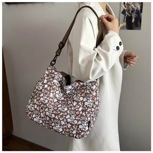 Detailed view of brown floral canvas tote bag featuring adjustable strap and side pockets