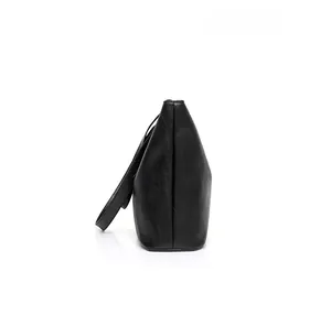 Side view of black leather tote bag showing structured silhouette and fine texture