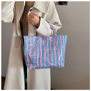 Détail du grand sac cabas rayé rose et bleu imperméable avec inscription TOTE BAG