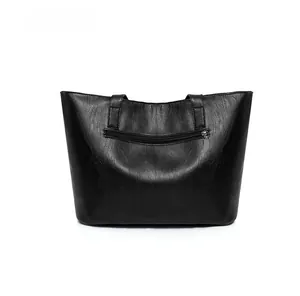 Close-up of black lychee grain leather tote bag featuring a rear functional zipper pocket