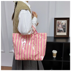 Vue portée d'un cabas à rayures avec revêtement en PVC et texte TOTE BAG