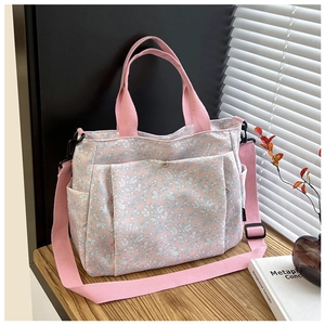 Detailed side view of pink floral tote bag with adjustable strap and side pockets