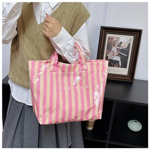 Sac fourre-tout à rayures roses et beige avec revêtement brillant porté par mannequin