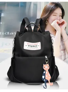 Détail d'un sac à dos en tissu Oxford imperméable avec charm chat et étiquette de marque