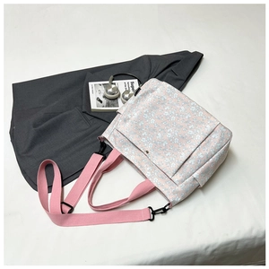 Detailed top view of pink floral canvas tote bag with front pocket and lifestyle props