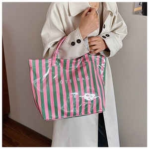 Gros plan d'un sac cabas à rayures roses et vertes avec fini brillant et logo blanc
