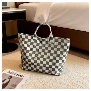 Macro shot of large black and white checkerboard tote bag with glossy waterproof surface