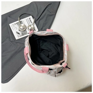 Detail showing the large capacity black lining and pink floral pattern of the tote bag