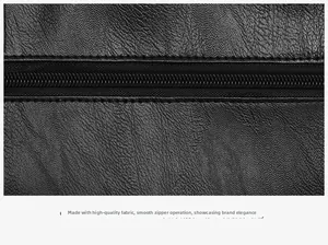 Close-up of smooth zipper on black pebbled leather tote bag showing fine stitching detail