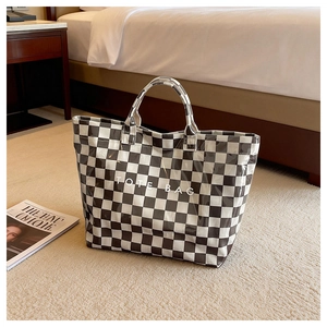 Detail of checkered tote bag in a hotel room, showing glossy waterproof PVC material