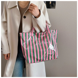 Sac fourre-tout imperméable à rayures roses et vertes porté par un mannequin en ville