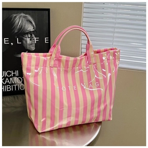 Gros plan du sac cabas à rayures roses et beige avec une finition vernie brillante