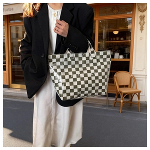 Close-up of checkered pattern tote bag with TOTE BAG lettering in street style scene