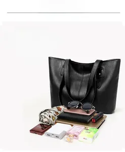 Spacious interior of black pebble leather tote bag showing organized daily essentials
